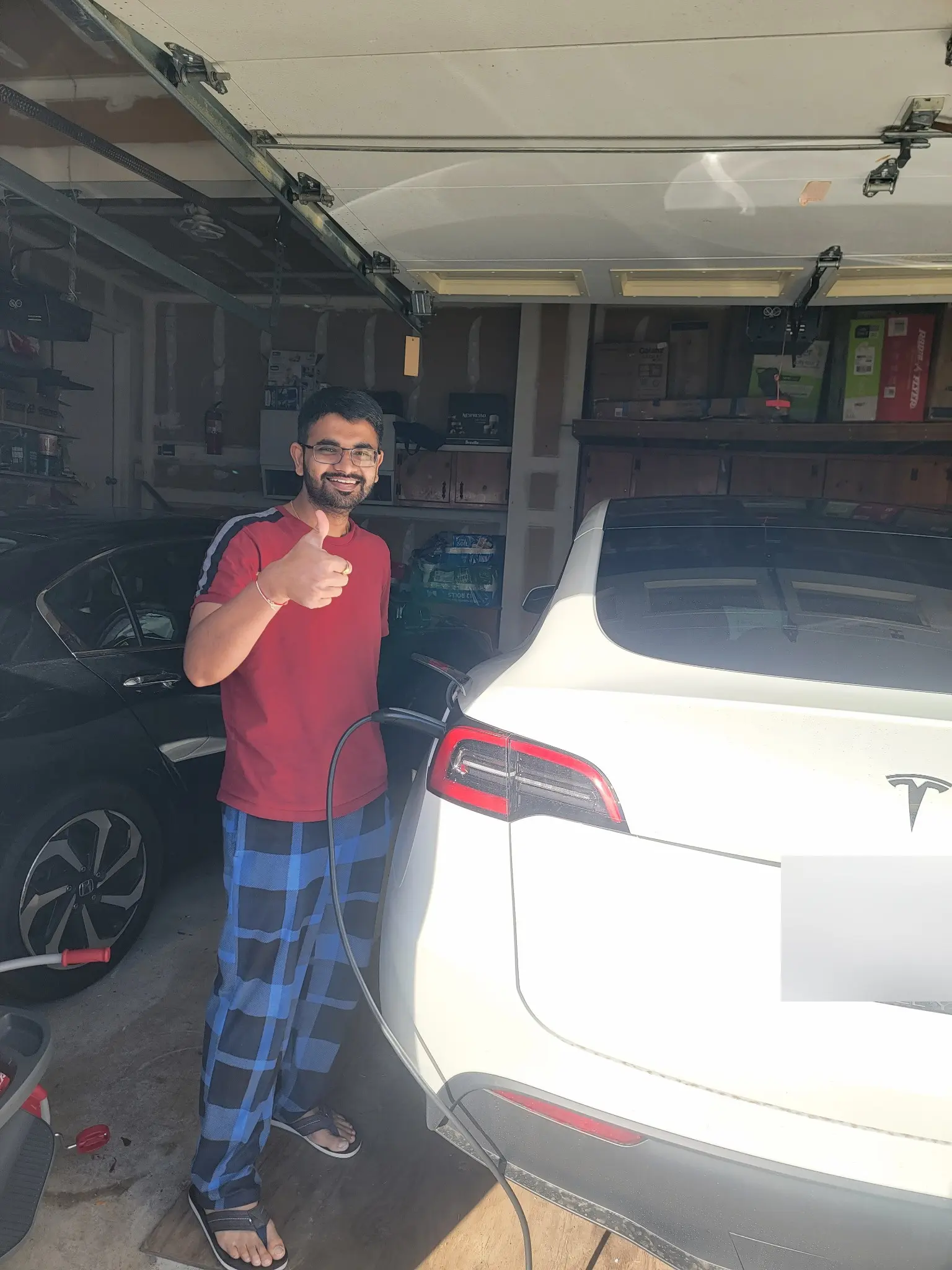 Homeowner giving a thumbs up next to a newly installed Tesla charger