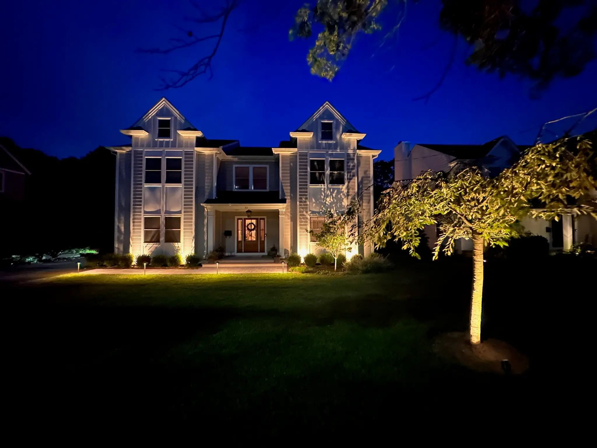 Home exterior illuminated with architectural and landscape lighting
