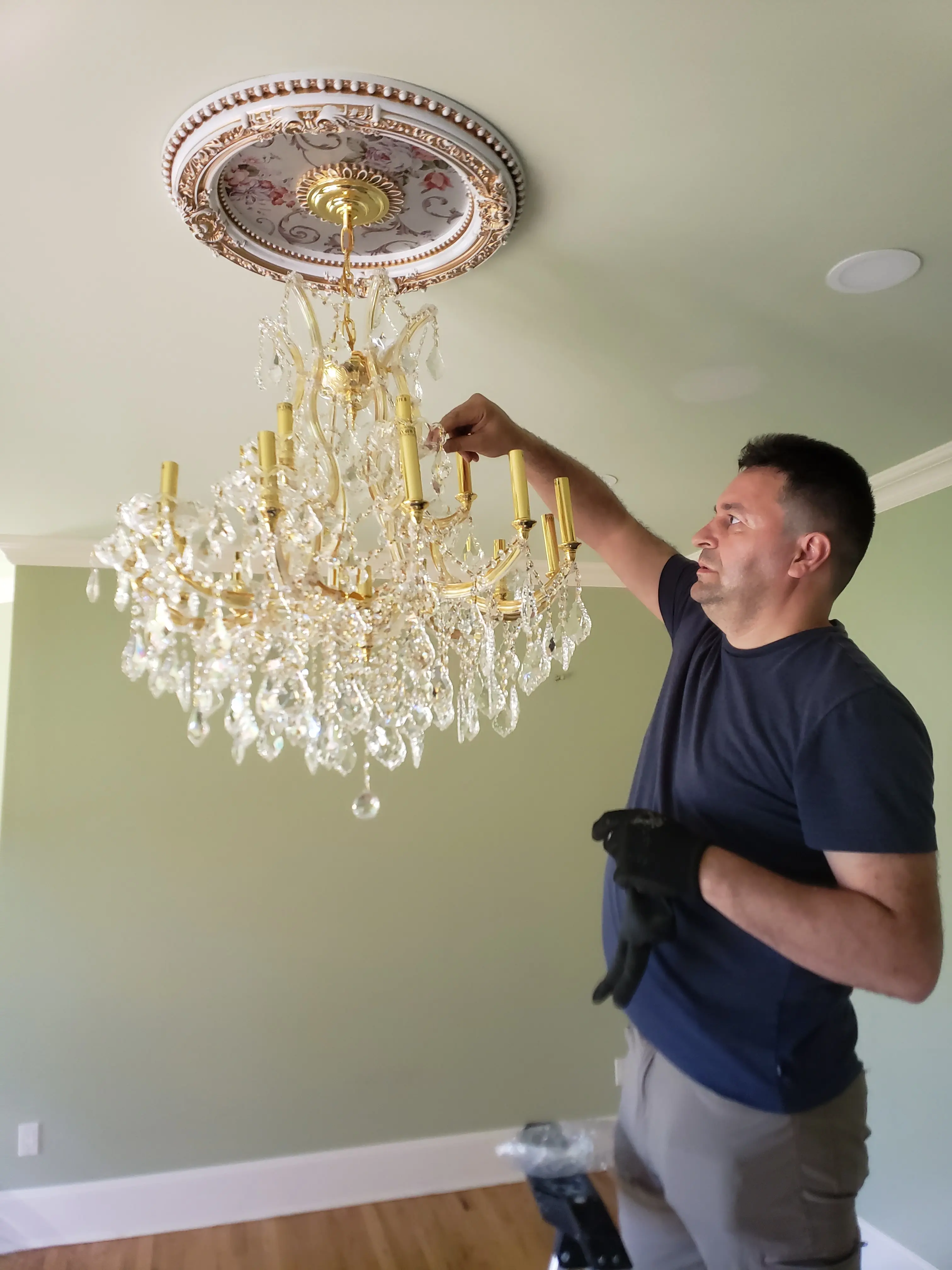 Art Power electrician installing a crystal chandelier