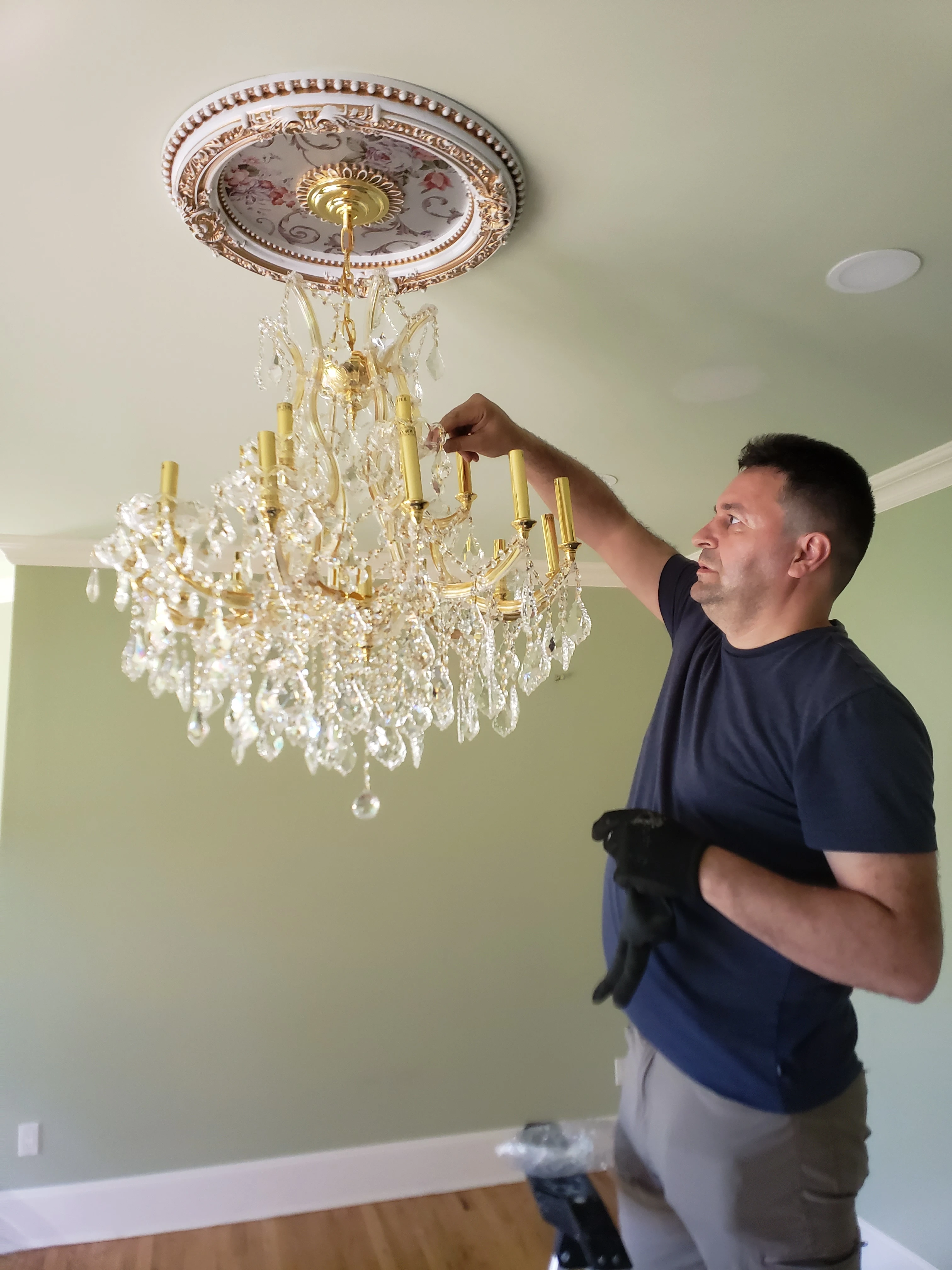 Art Power electrician installing a crystal chandelier