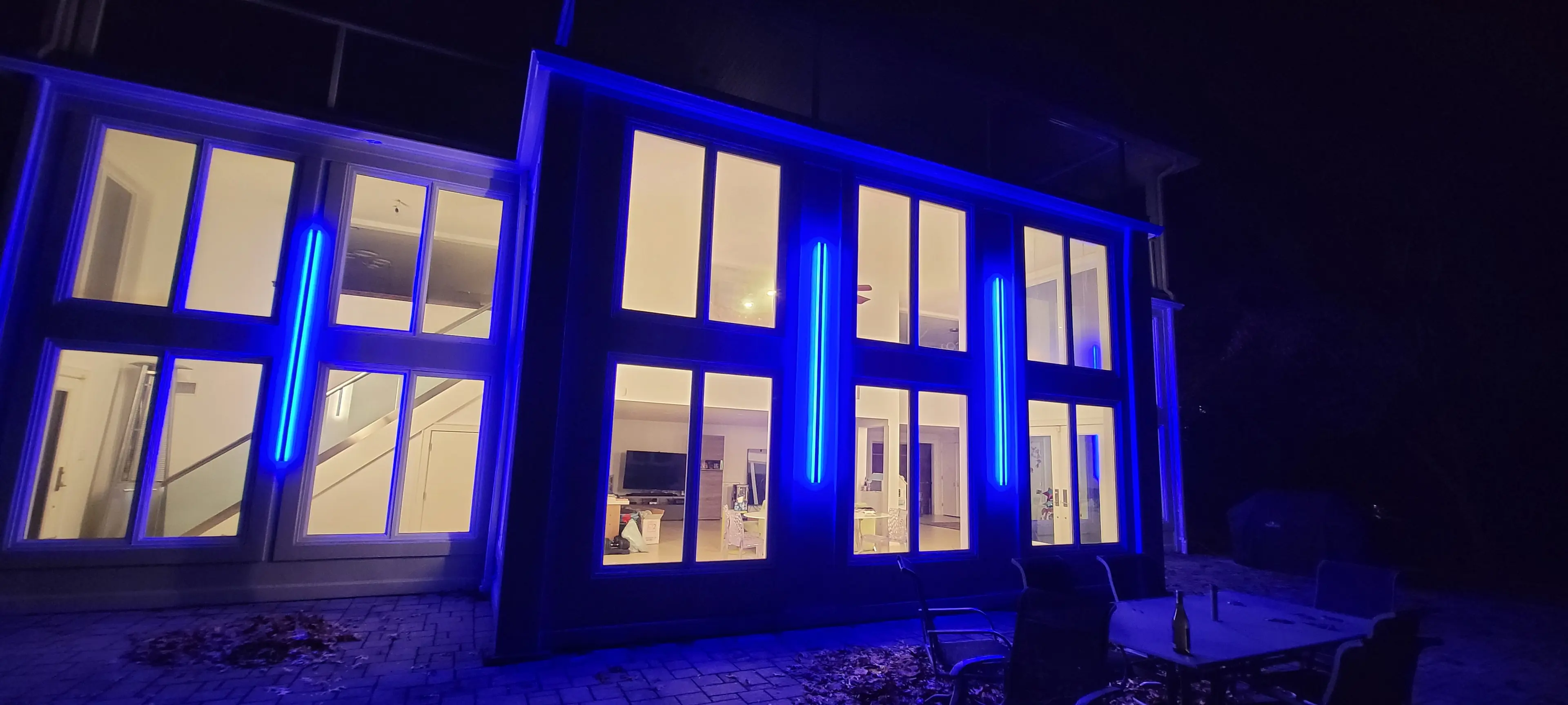 Blue exterior accent lighting installed on the rear of a home