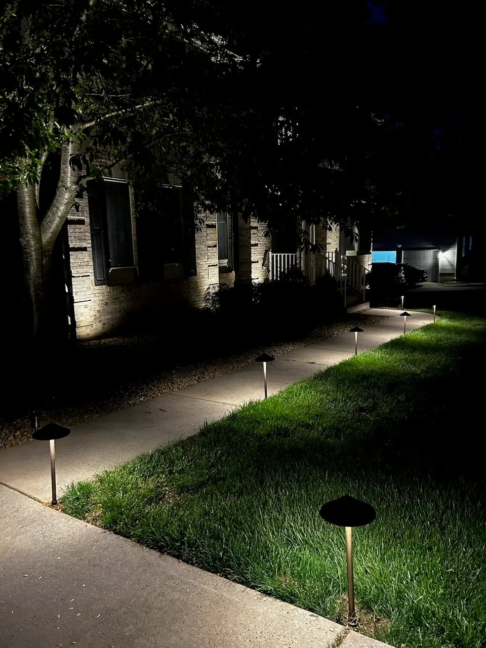 Landscape path lights illuminating a residential walkway at night