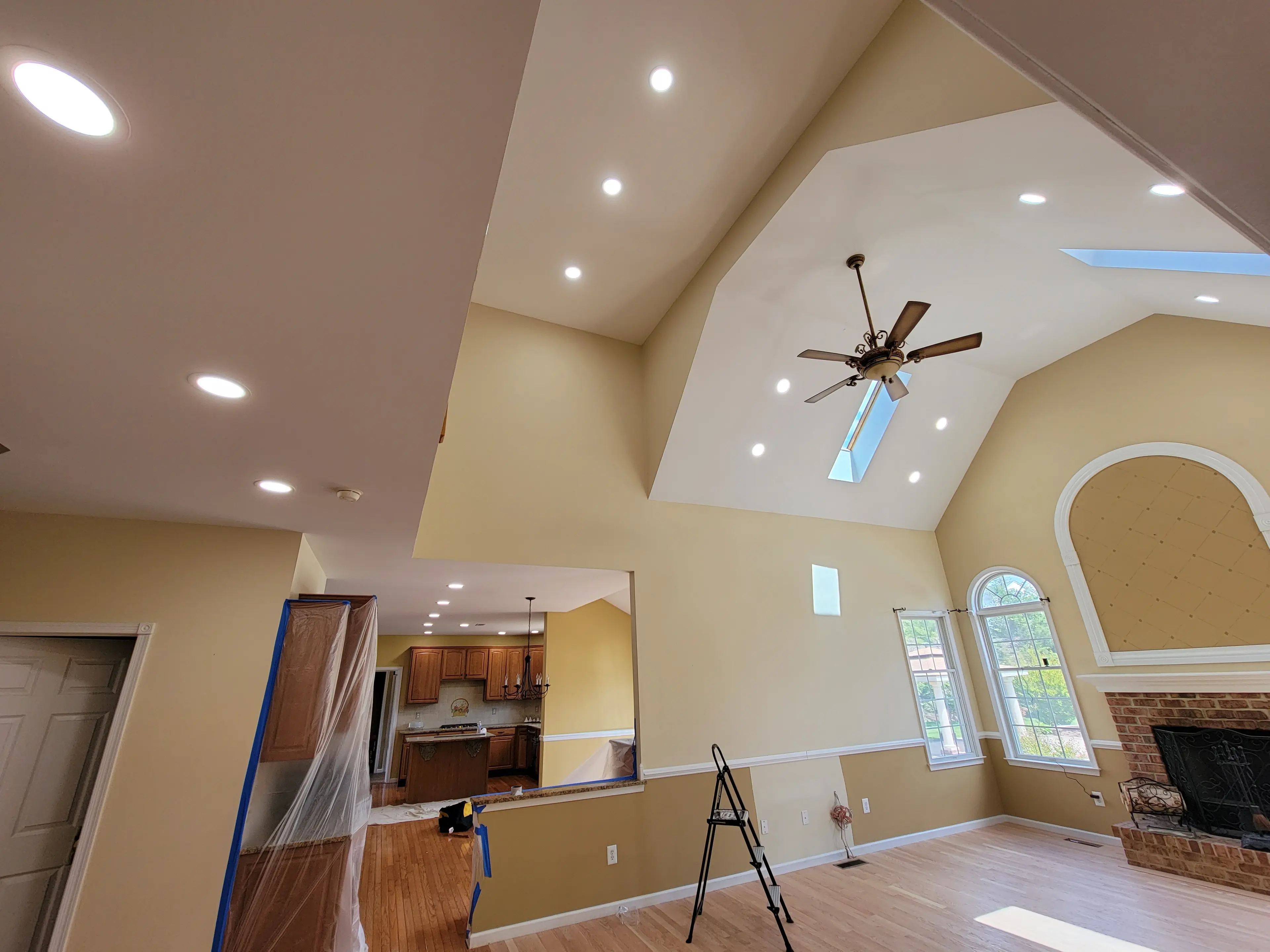 Recessed lighting across a vaulted ceiling in an open residential living space