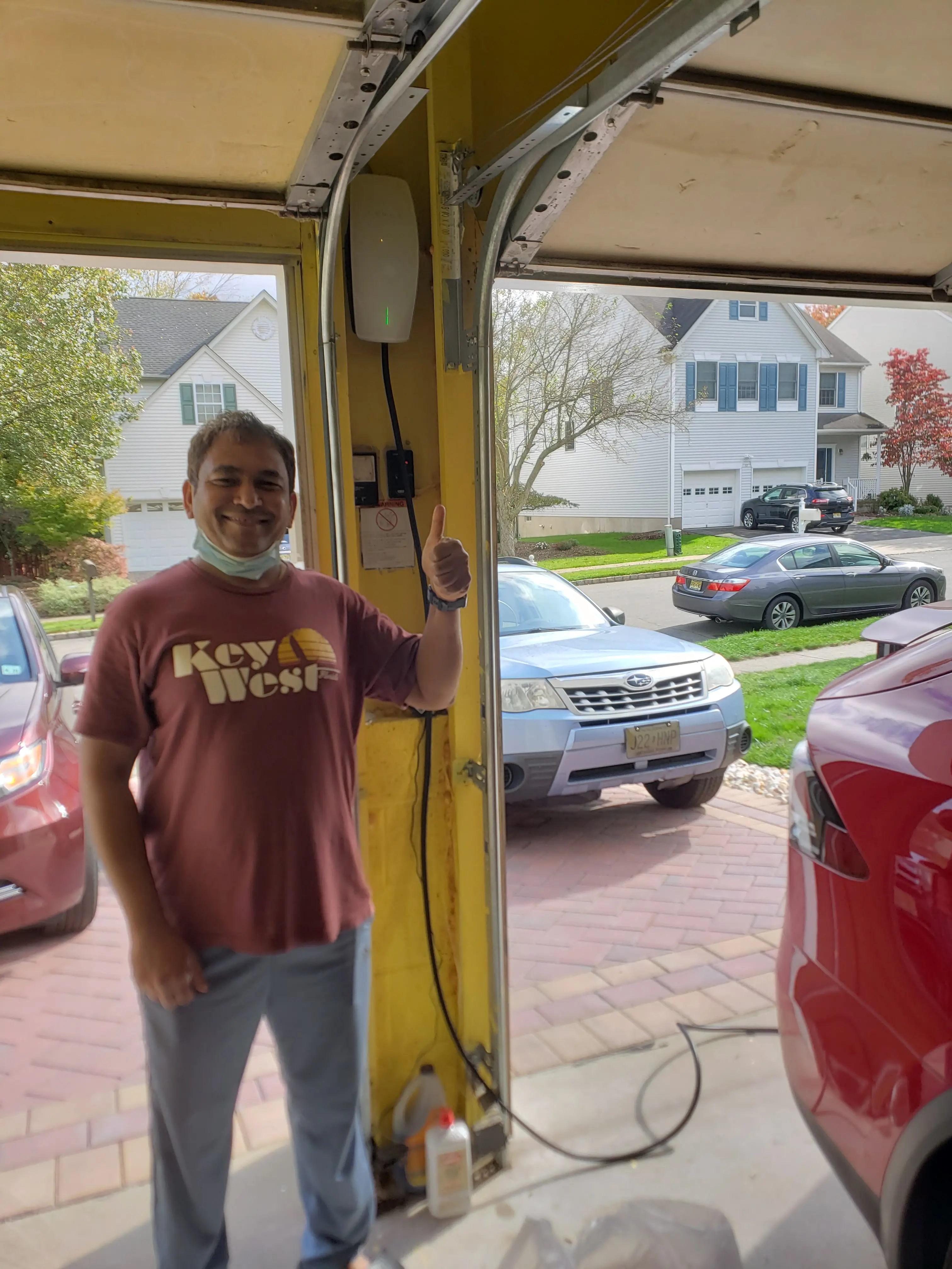 Customer next to a newly installed Tesla Wall Connector in a home garage